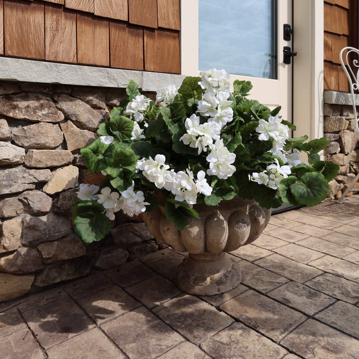outdoor planter filled with artificial realistic geraniums