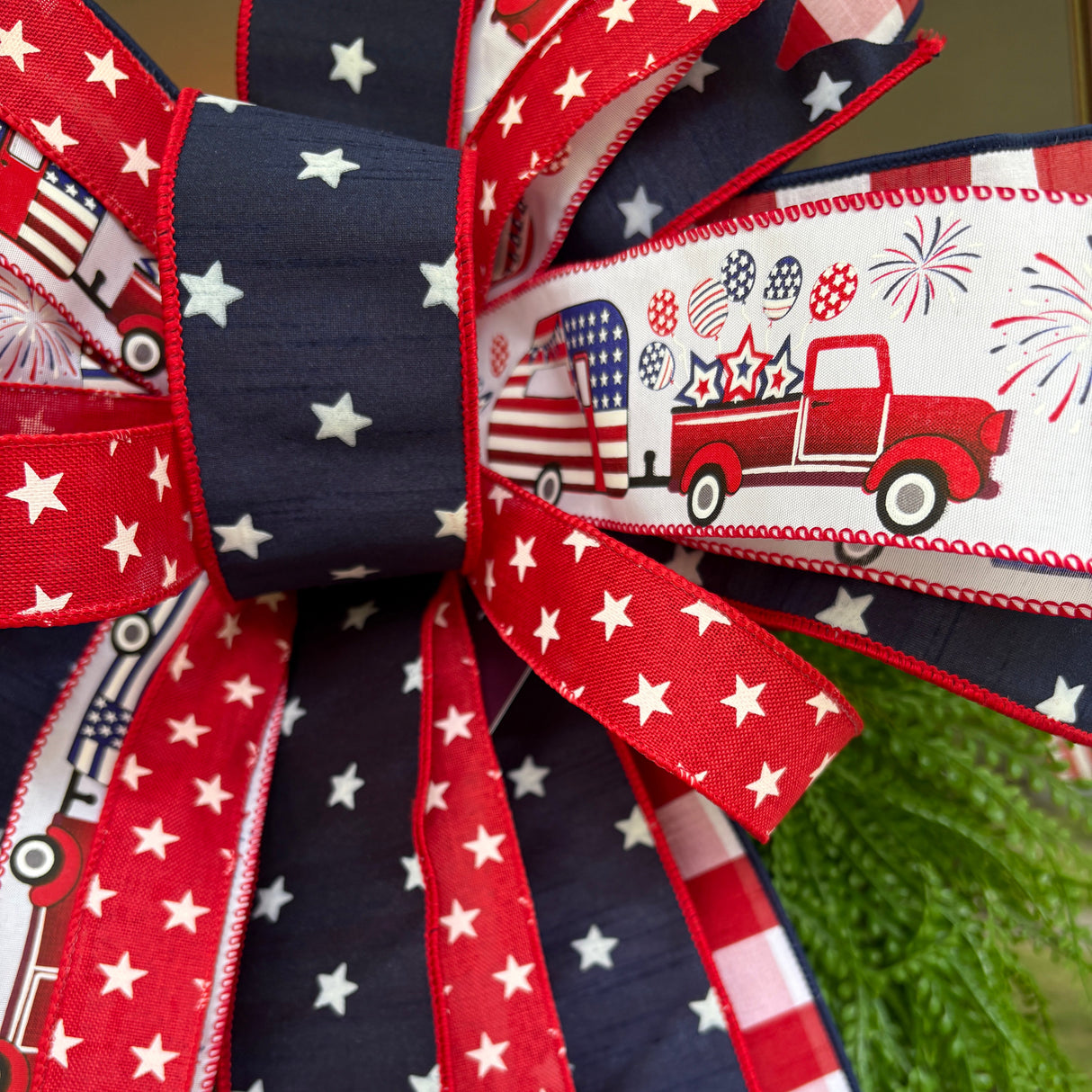 Decorative bow with American flag and fire truck pattern on a green background