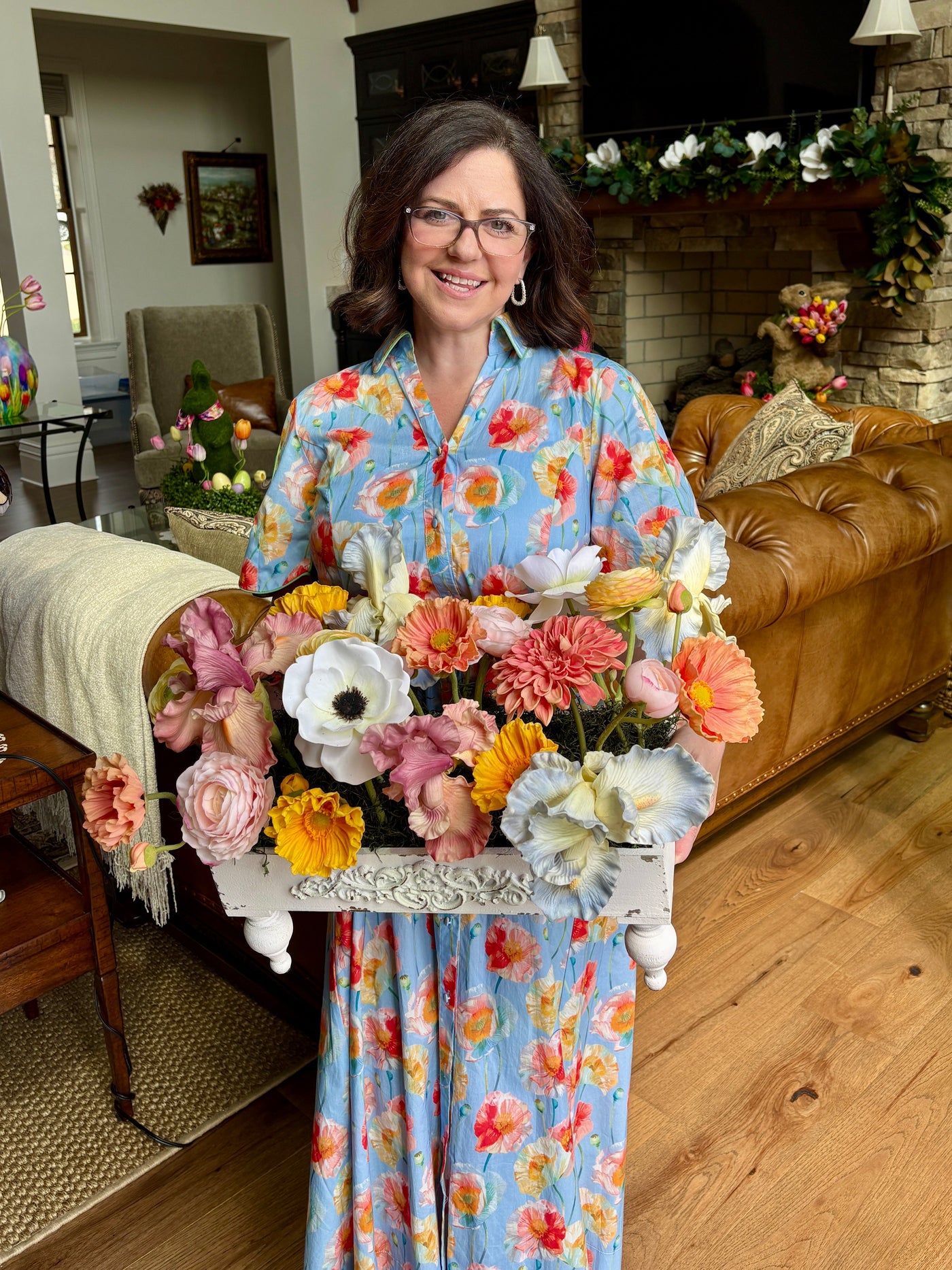 Woman holding a large floral arrangement in a living room setting