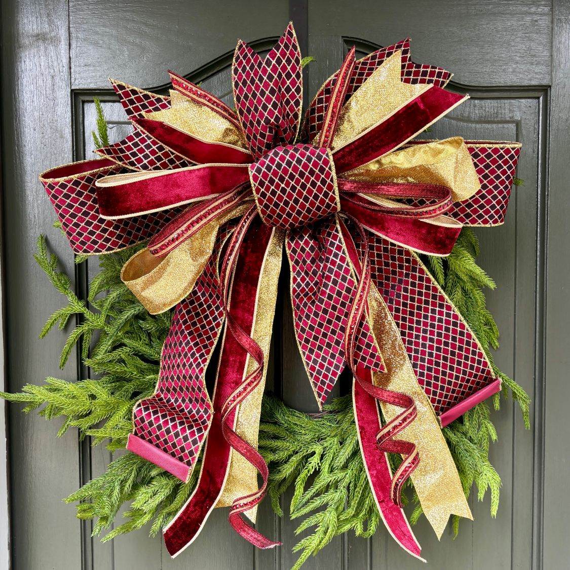 20 inch Burgundy Christmas hand-tied designer bow with burgundy velvet, gold glitter and jeweled lattice ribbon, on a wreath