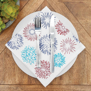 Napkin with colorful firework design on a wooden table with cutlery