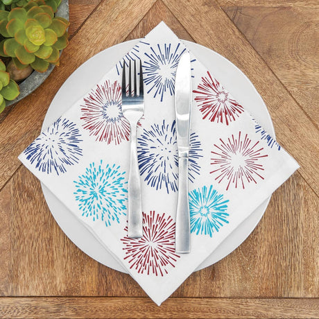 Napkin with colorful firework design on a wooden table with cutlery
