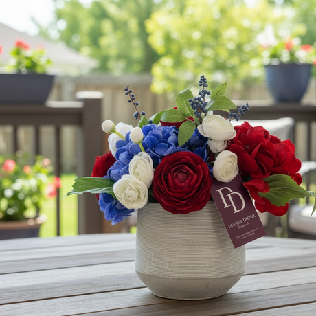 Floral arrangement in a pot on a table with a blurred outdoor background