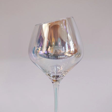 Clear irredescent wine glass on a white background