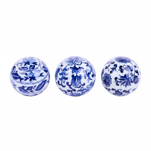 Three blue and white ceramic balls with intricate patterns on a white background