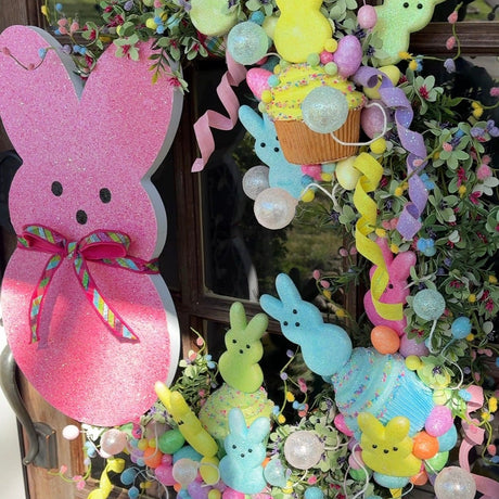 Colorful Easter wreath with Peeps bunny figures on a door.
