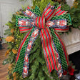 20 inch Navy Nutcracker hand-tied Christmas designer bow with navy nutcracker print, emerald diamond and red-green glitter stripe ribbon, on a garland