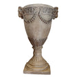 Decorative stone urn against a plain wall