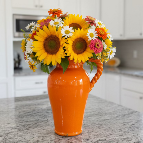 Orange vase with a handle on a kitchen counter