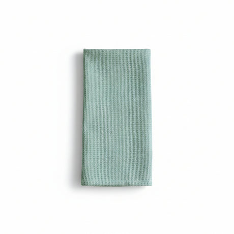 Folded light blue waffle-textured towel on a white background