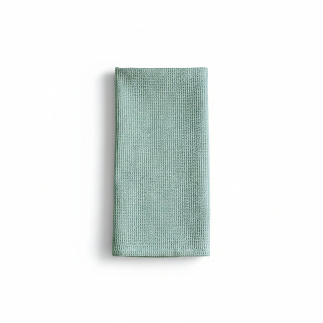 Folded light blue waffle-textured towel on a white background