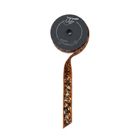 A roll of Farrisilk wired ribbon with a dark gray spool, shown on a light wood background. The ribbon features a metallic bronze glitter border with small black and orange sequins.