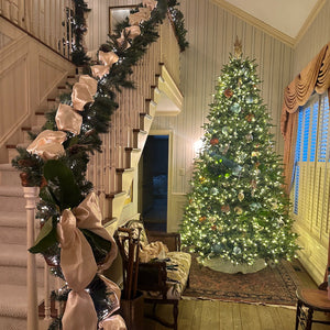 Decorated Christmas tree with garland and ribbons in a home setting.