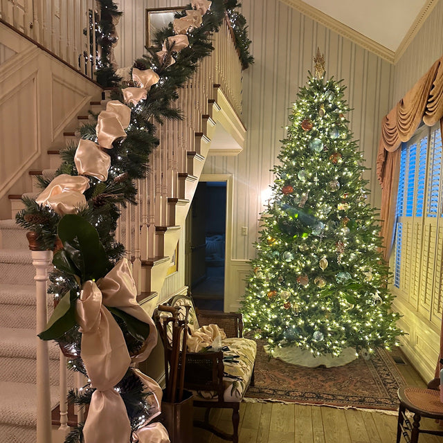 Decorated Christmas tree with garland and ribbons in a home setting.