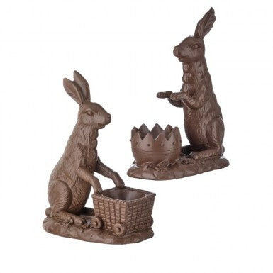 Two brown rabbit statues with a basket and another rabbit holding a basket on a white background