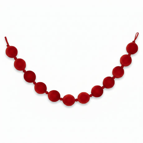 A red velvet ball garland made of large, round fabric balls strung on a velvet cord, shown against a plain white background.