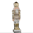 A vintage-style nutcracker figurine with a distressed silver and gold finish, featuring a pink face, white beard, and standing on a small base against a black background.