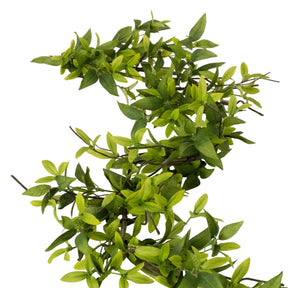 Artificial green leafy branch on a white background