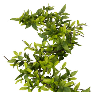 Artificial green leafy branch on a white background